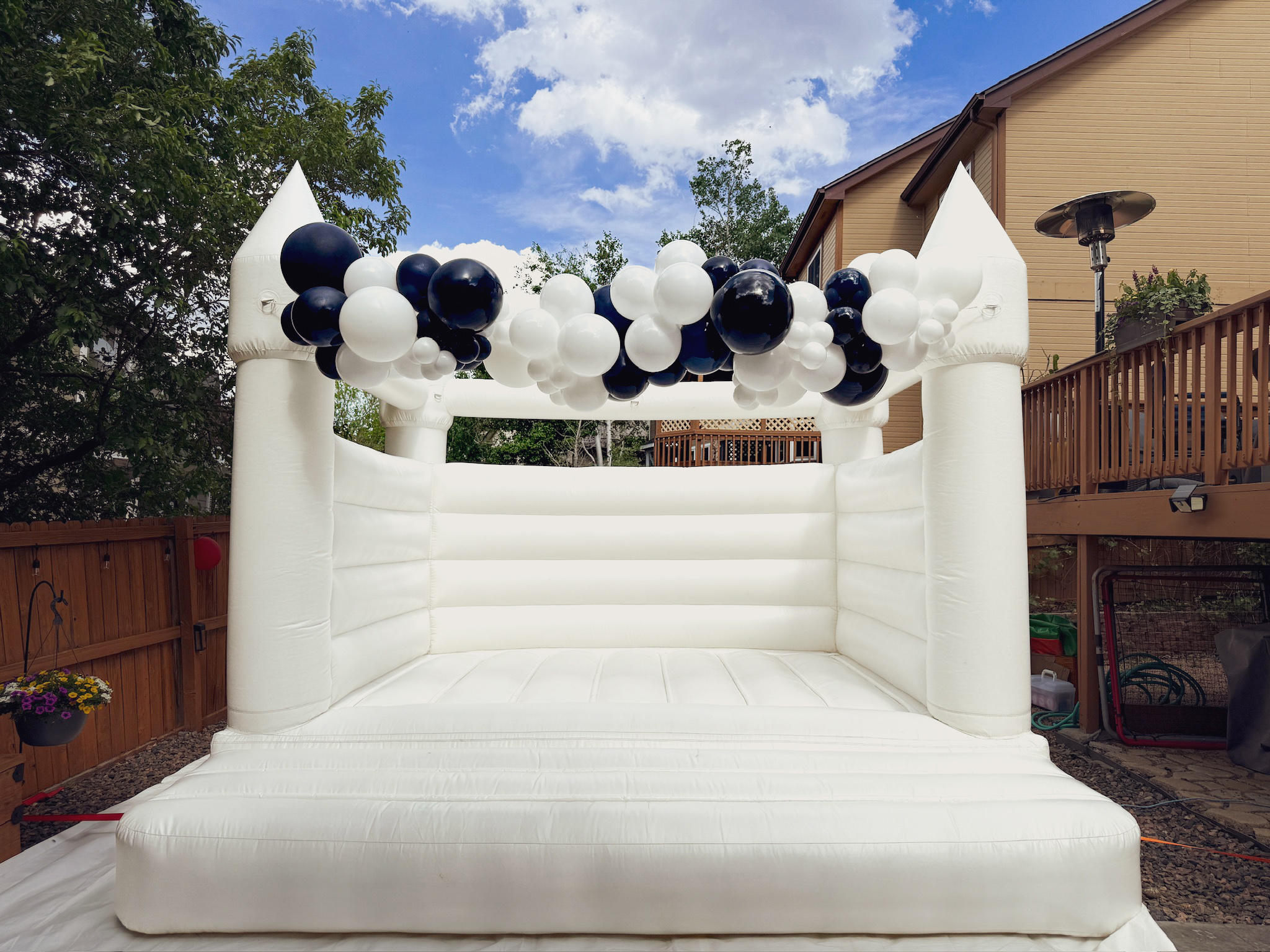 white bounce house rental available in Denver and surrounding areas. Includes balloon garland installation. Perfect inflatable for kids and adults in Colorado