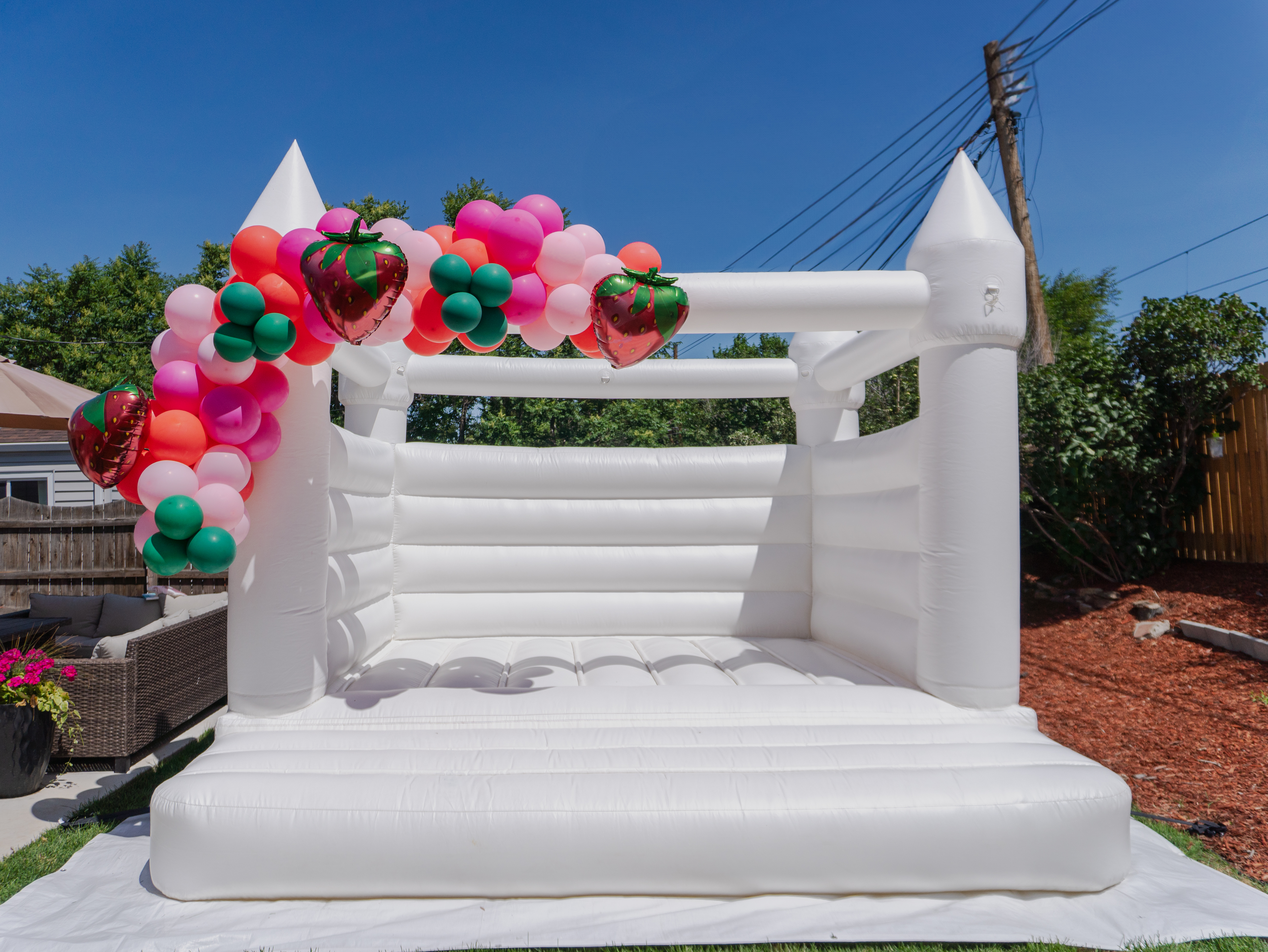 Modern white bounce house rental in Denver by Chuchi’s Events – perfect for weddings, kids’ parties, and stylish celebrations of all kinds. Customized with balloon decor