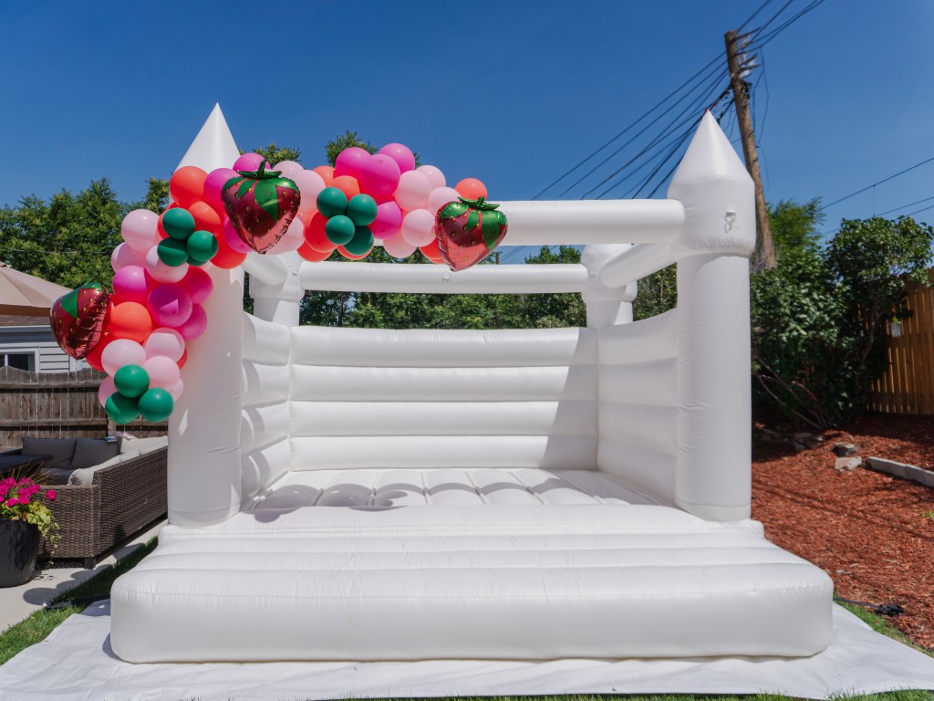 Modern white bounce house rental in Denver by Chuchi’s Events – perfect for weddings, kids’ parties, and stylish celebrations of all kinds. Customized with balloon decor