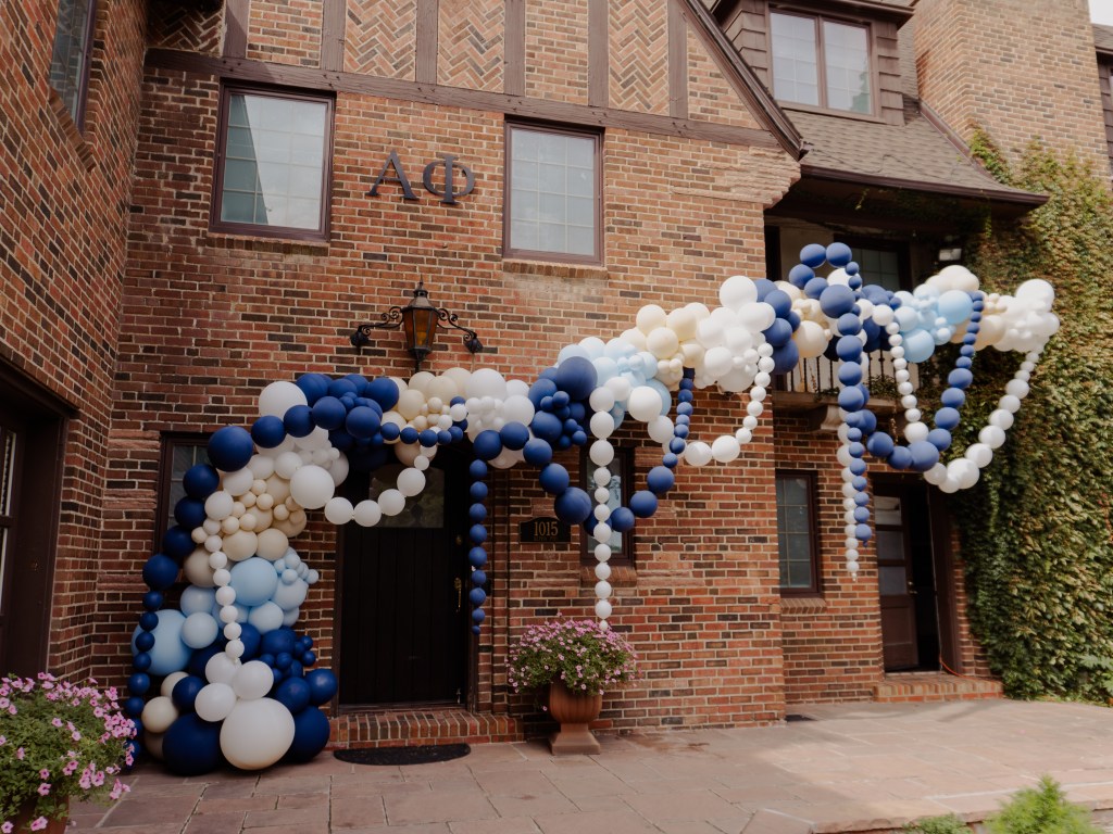 Luxury balloon garland installation with navy, white, and champagne balloons at a Boulder sorority house. Custom balloon décor for college events, bid day, and special celebrations in Denver and Colorado