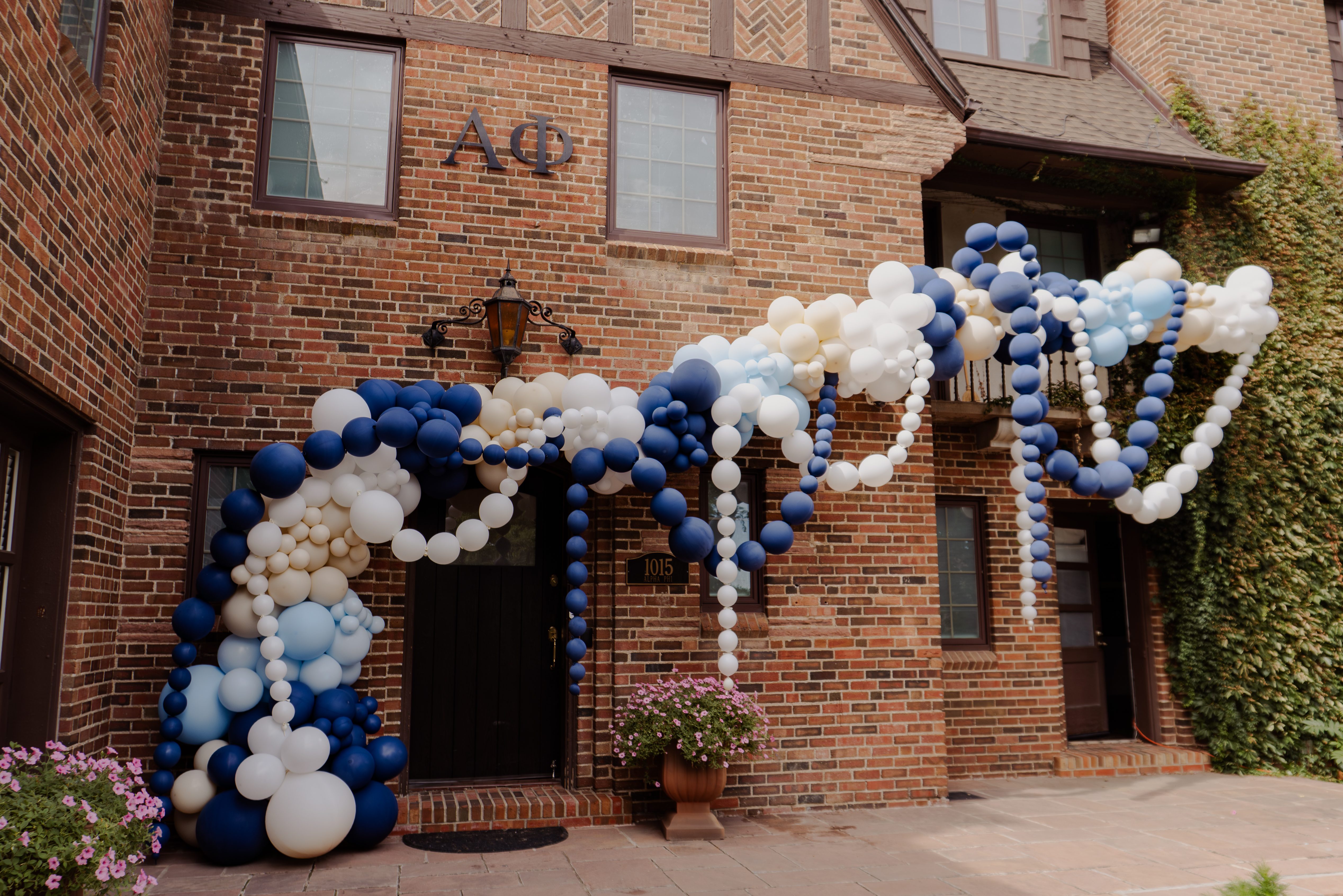 Luxury balloon garland installation with navy, white, and champagne balloons at a Boulder sorority house. Custom balloon décor for college events, bid day, and special celebrations in Denver and Colorado